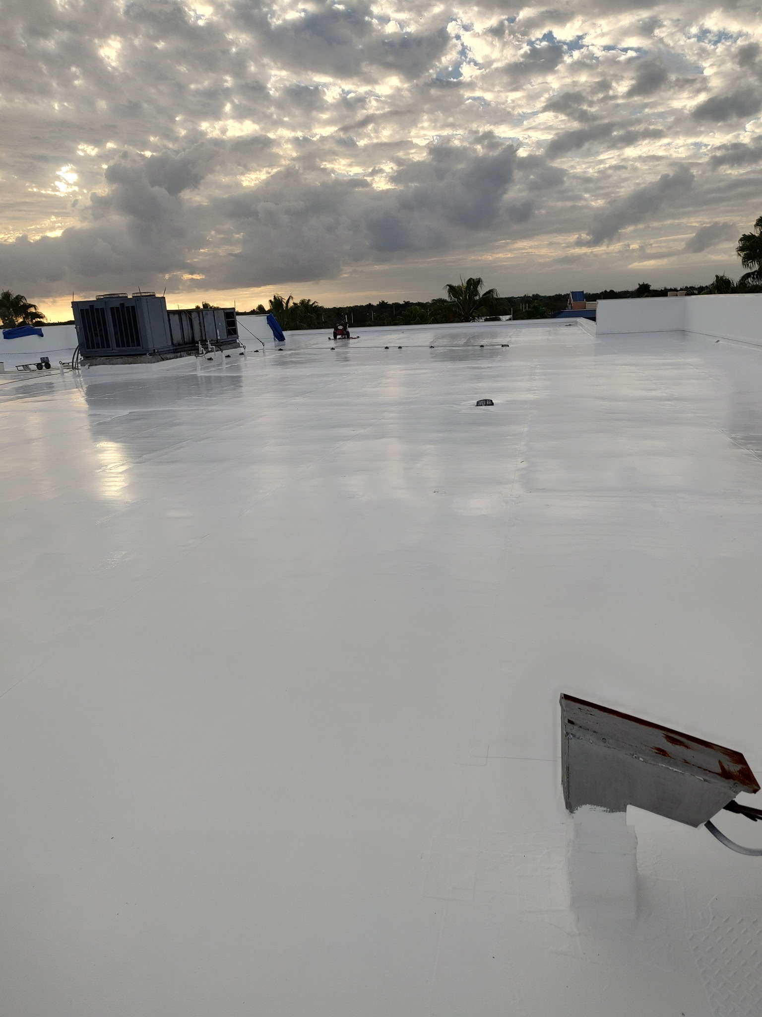 Completed white roof coating at sunset
